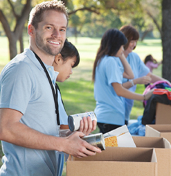 "Volunteers for Catholic Charities Maine  help sort donations of food and clothing into boxes.